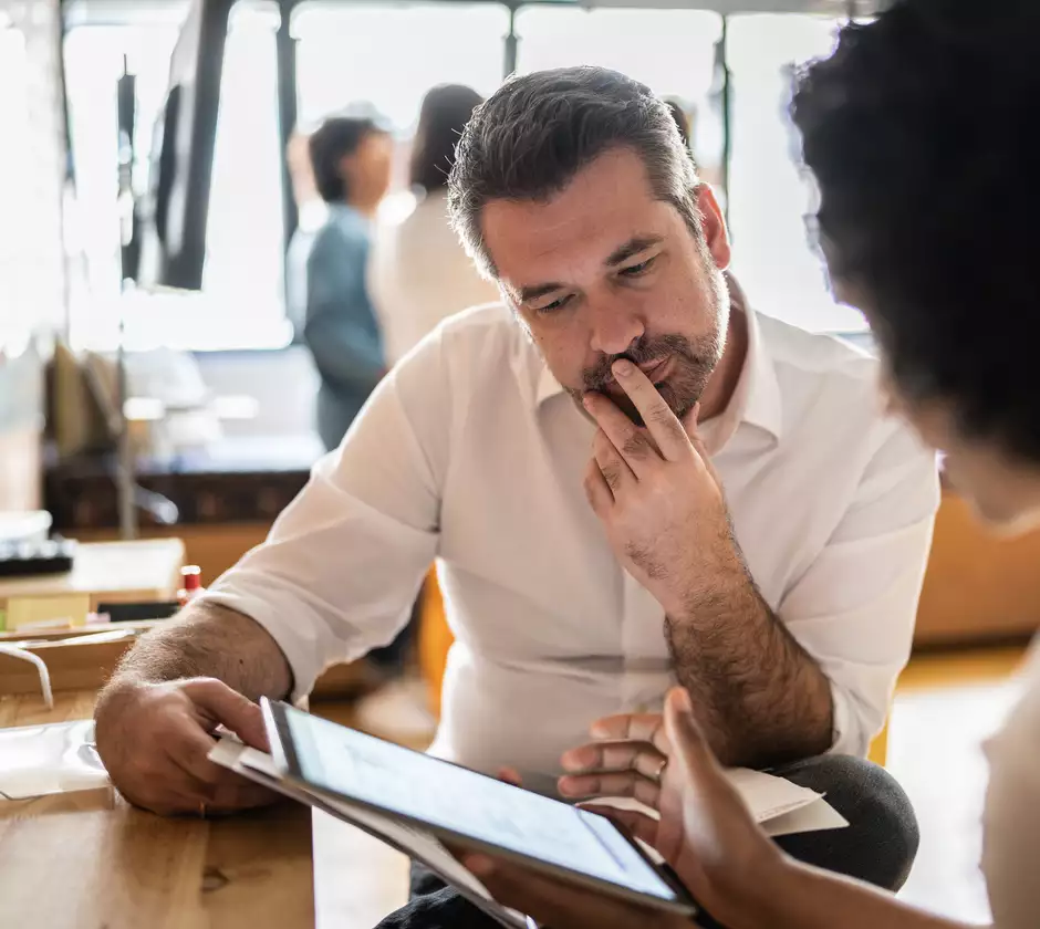 Un homme et une femme qui regardent et analysent les données techniques sur une tablette